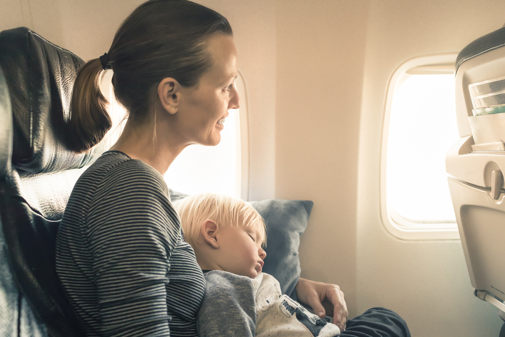 Enfant qui dort sur sa maman dans l'avion