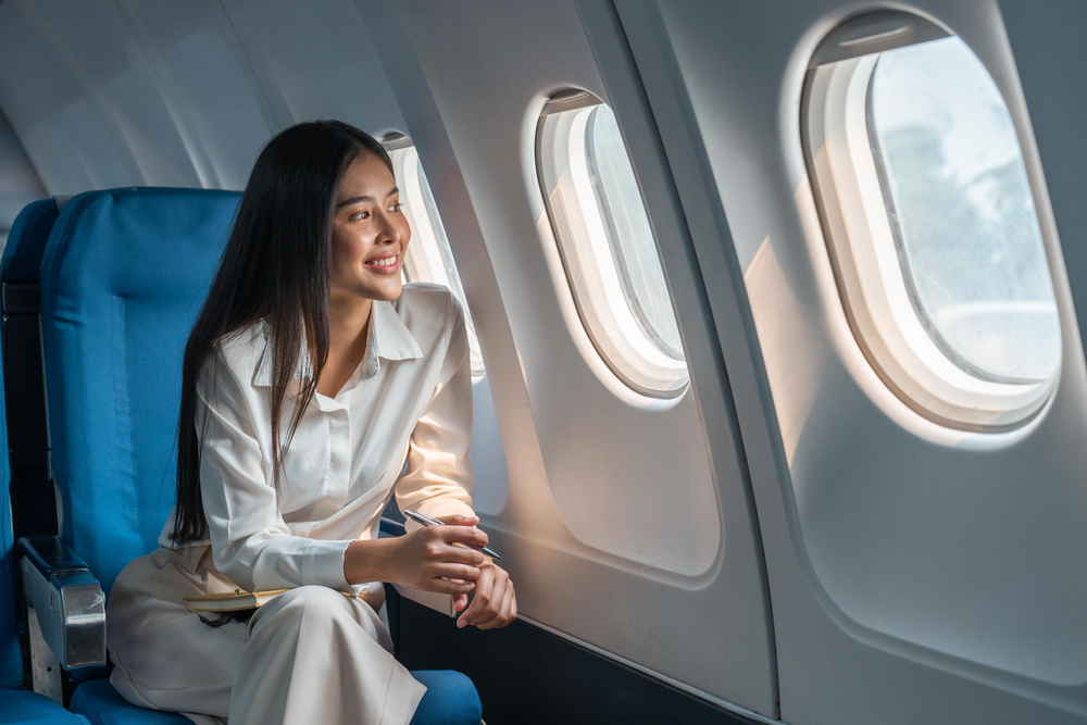 Femme dans l'avion regardant par hublot