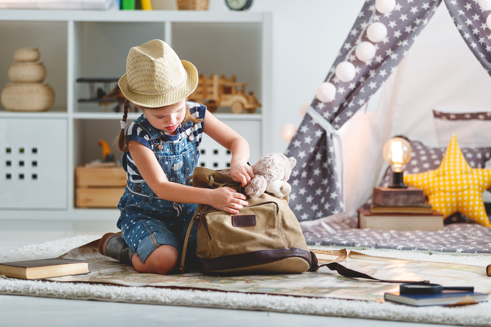 Petite fille, prépare son sac de voyage