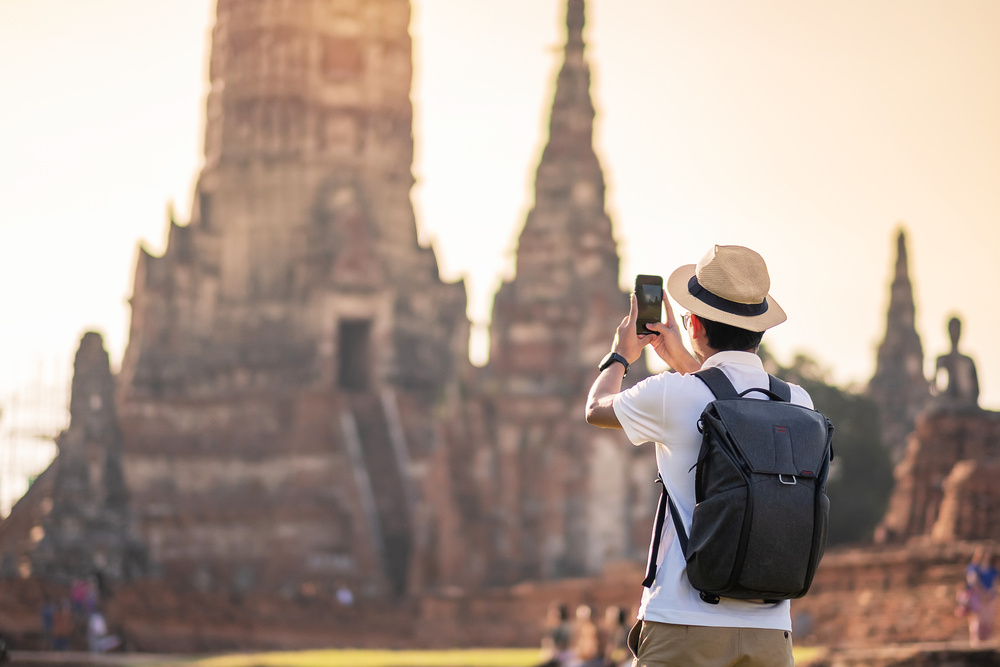 Touriste prenant une photo d'un temples en Thailande