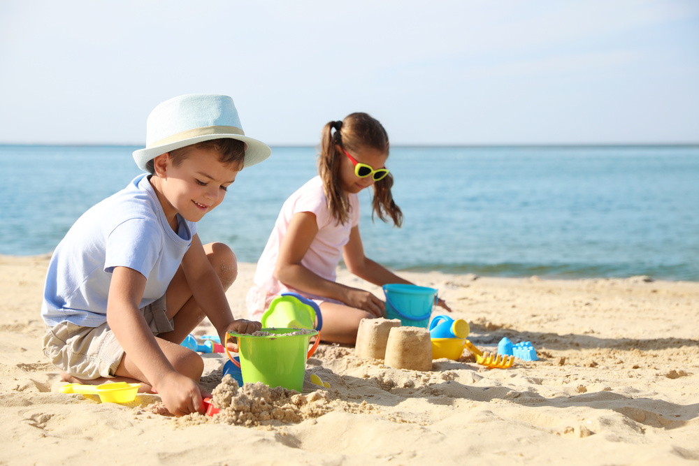 Des enfants qui construisent un château de sable à la plage