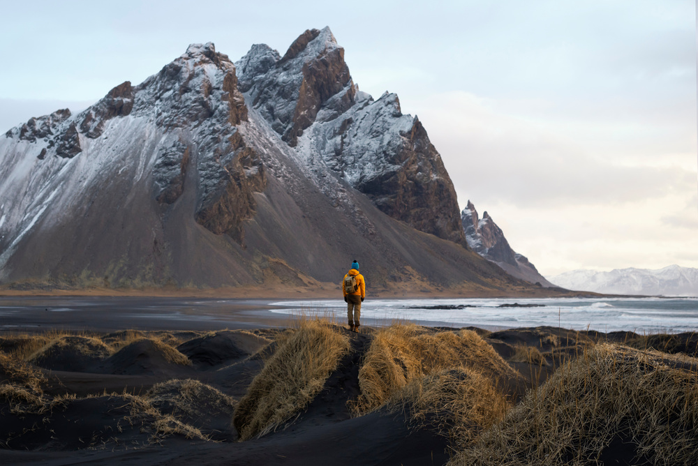 Un touriste admire la montagne Vestrahorn, Islande